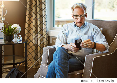 Home, phone or mature man on social media with internet connection or website notification on chair. Glasses, search or senior person texting on networking mobile app chat or reading news to relax Home, phone or mature man on social media with internet connection or website notification on chair. Glasses, search or senior person texting on networking mobile app chat or reading news to relax 138682516