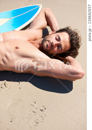 Beach sports, surf and man sleeping, relax and tired after activity, training or natural outdoor wellness on Canada vacation. Surfboard, sunshine and holiday surfer fatigue, rest and dream on sand 138682657