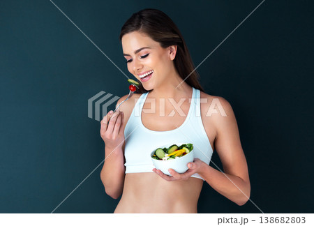 Happy woman, salad bowl and eating for diet, lose weight or natural nutrition in fitness against a studio background. Female person or model smile with vegetables for food or healthy meal on mockup 138682803