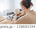 Woman sewing denim on sewing machine at home, handmade clothing and tailoring concept 138683194