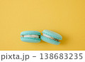 Pair of turquoise macarons on solid bright yellow background, vibrant contrast food photography for creative design 138683235