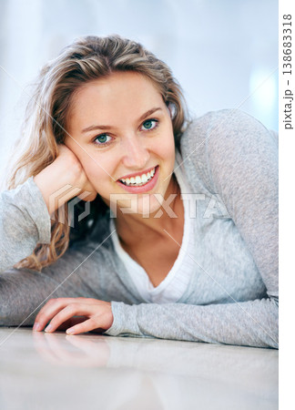 Woman, portrait and floor lying smile in home for cheerful friendly, calm or feminine look. Female person, happy face and hand on ground for attractive, lazy weekend joy or positive relax in Canada 138683318