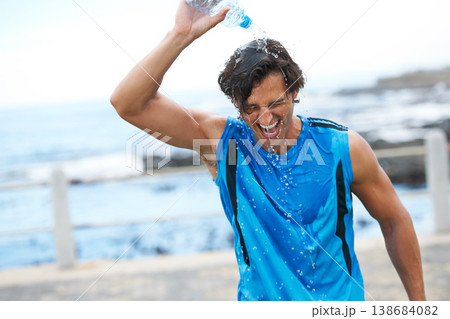 Man, fitness and pouring water on head to hydrate, laughing and fun in cardio training. Happy male athlete, liquid and refreshment from exercise, workout and running by ocean, sea and outdoor play 138684082