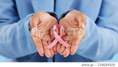 Hands, pink ribbon and breast cancer support with awareness and healthcare icon on blue background. Person in studio, medical symbol and wellness with care, trust and kindness in solidarity campaign 138684920