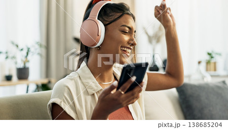 Phone, music and happy woman dance on sofa in home, singing and listening to audio. Smartphone, excited Indian person on headphones and radio, sound or freedom in living room on mobile app technology Phone, music and happy woman dance on sofa in home, singing and listening to audio. Smartphone, excited Indian person on headphones and radio, sound or freedom in living room on mobile app technology 138685204