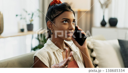 Phone call, fighting and young woman on a sofa for communication in the living room of apartment. Argument, annoyed and Indian female person on mobile conversation with cellphone in lounge at home. Phone call, fighting and young woman on a sofa for communication in the living room of apartment. Argument, annoyed and Indian female person on mobile conversation with cellphone in lounge at home. 138685334