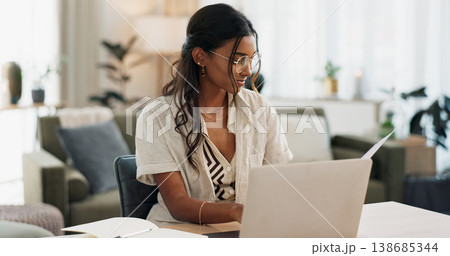Laptop, remote work and woman reading for research in the living room of modern apartment. Smile, technology and young Indian female freelancer working on creative project with computer at home. 138685344