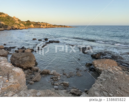 Coastal landscape with rocky shoreline, clear sky, and calm sea during daylight, ideal as background Coastal landscape with rocky shoreline, clear sky, and calm sea during daylight, ideal as background 138685822