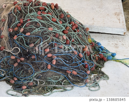 Fishing nets with colorful floats tangled on wooden dock background 138685845