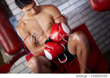 Fitness, gym and a man with gloves for boxing, cardio and getting ready for a match. Strong, exercise and a boxer, fighter or athlete with equipment to start a martial arts competition at a club Fitness, gym and a man with gloves for boxing, cardio and getting ready for a match. Strong, exercise and a boxer, fighter or athlete with equipment to start a martial arts competition at a club 138685938