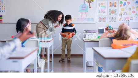 Teacher, child and reading a book in class for learning, development and communication. A boy kid or student and woman teaching language, support and assessment in elementary classroom at school Teacher, child and reading a book in class for learning, development and communication. A boy kid or student and woman teaching language, support and assessment in elementary classroom at school 138686136