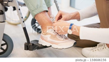 Caregiver, help and senior woman in wheelchair with shoes in closeup for comfort, care. Nurse, hand and sneakers for elderly person with disability in retirement home for support with medical worker. Caregiver, help and senior woman in wheelchair with shoes in closeup for comfort, care. Nurse, hand and sneakers for elderly person with disability in retirement home for support with medical worker. 138686156