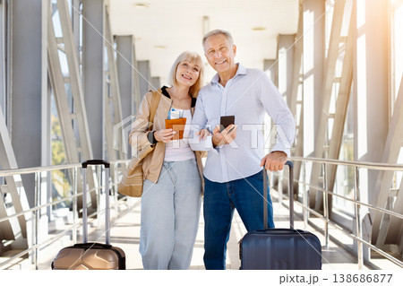 Happy mature couple posing in airport, woman holding passport with boarding pass 138686877