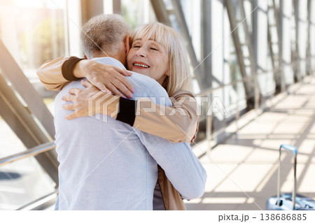 Closeup of happy mature woman joyfully embracing man in airport corridor 138686885