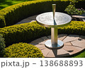 Modern Sundial Sculpture in Hedge Garden 138688893