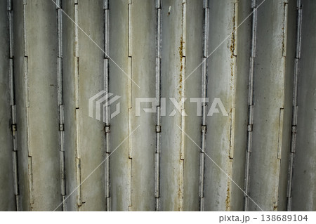 Close-up of old shutter door. Metallic rusty texture stripe pattern on door. For background. Close-up of old shutter door. Metallic rusty texture stripe pattern on door. For background. 138689104