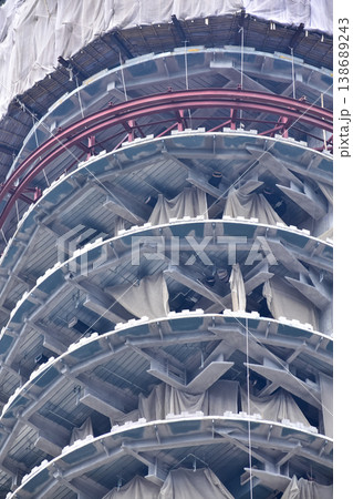 Close-up of the construction site at daytime. The office building under restoration. A large scale construction site of an office tower with steel bars. Urban development. 138689243