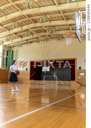 体育館でバスケットボールを持つ女子高生 138690444