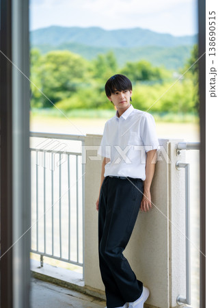 屋外のベランダで立つ男子学生 138690515