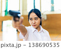 銃を構えて横を見る女子高生 138690535