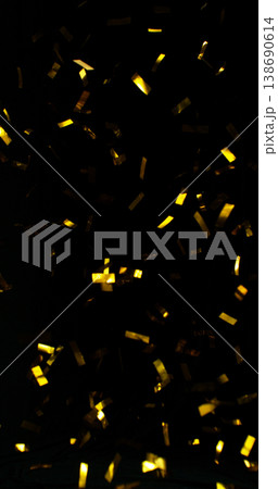 Flying golden confetti on black background. Shiny particles suspended in the air with dramatic lighting, creating a festive, luxury and celebratory atmosphere. 138690614