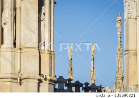 Marble statues and architecture on roof of Duomo gothic cathedral in Milan 138690821