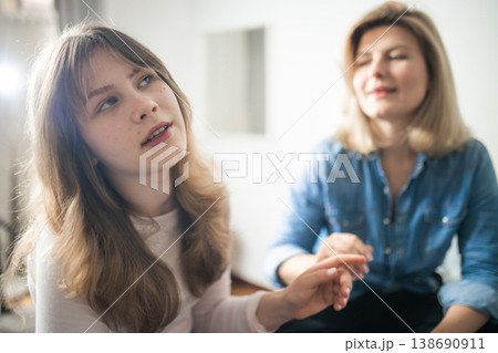 Young woman reaching hand to her mother figure for connection Young woman reaching hand to her mother figure for connection 138690911