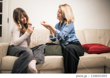 Two women sharing a moment applying makeup 138691005