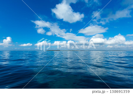 clouds on blue sky over calm sea with sunlight reflection clouds on blue sky over calm sea with sunlight reflection 138691359