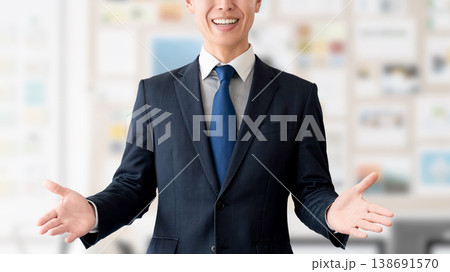 笑顔で案内する男性ビジネスマン 笑顔で案内する男性ビジネスマン 138691570