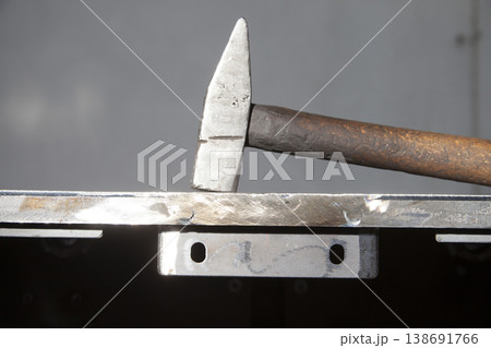 wooden handle hammer on steel plate 138691766