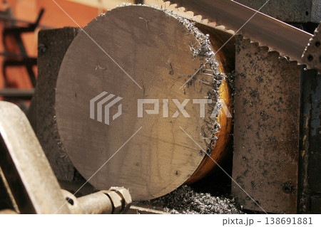 Automatic bandsaw sawing metal workpiece. Automatic bandsaw sawing metal workpiece. 138691881
