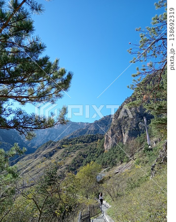 Bright summer day landscape of the Caucasus Mountains, North Ossetia, Russia. Sunlit green slopes, jagged ridges and peaceful highland scenery stretching to the horizon 138692319
