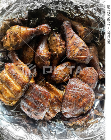 Delicious smoked chicken parts on metal foil after grilling in a BBQ smoker outdoors 138692399
