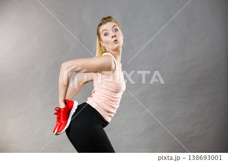Happy woman presenting sportswear trainers shoes Happy woman presenting sportswear trainers shoes 138693001