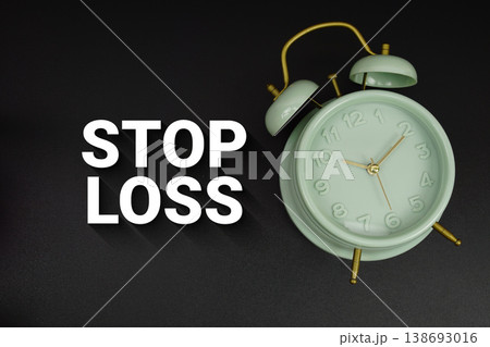 Stop Loss text with alarm clock on black background 138693016