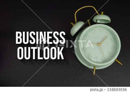 Business Outlook text with alarm clock on black background Business Outlook text with alarm clock on black background 138693036