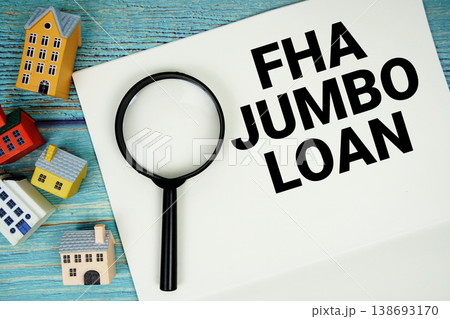 Notepad with "FHA Jumbo Loan" with magnifying glass and house model on wooden background 138693170