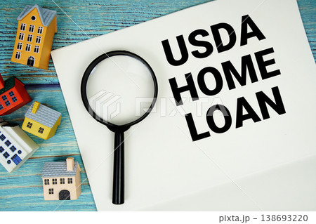 Notepad with "USDA Home Loan" with magnifying glass and house model on wooden background Notepad with "USDA Home Loan" with magnifying glass and house model on wooden background 138693220