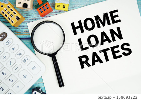 Notepad with "Home Loan Rates" with Calculator, magnifying glass and house model on wooden background Notepad with "Home Loan Rates" with Calculator, magnifying glass and house model on wooden background 138693222