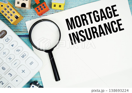 Notepad with "Mortgage Insurance" with Calculator, magnifying glass and house model on wooden background 138693224