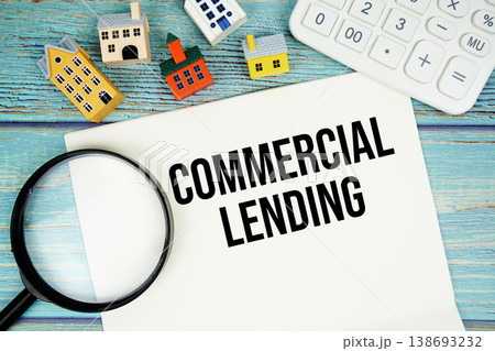 Notepad with "Commercial Lending" with Calculator, magnifying glass and house model on wooden background Notepad with "Commercial Lending" with Calculator, magnifying glass and house model on wooden background 138693232