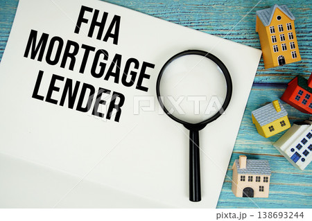 Notepad with "FHA Mortgage Lender" with magnifying glass and house model on wooden background Notepad with "FHA Mortgage Lender" with magnifying glass and house model on wooden background 138693244