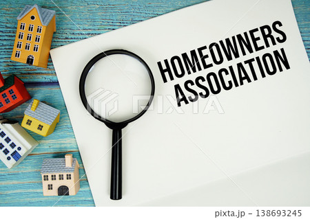 Notepad with "HOA Homeowners Association" with magnifying glass and house model on wooden background Notepad with "HOA Homeowners Association" with magnifying glass and house model on wooden background 138693245