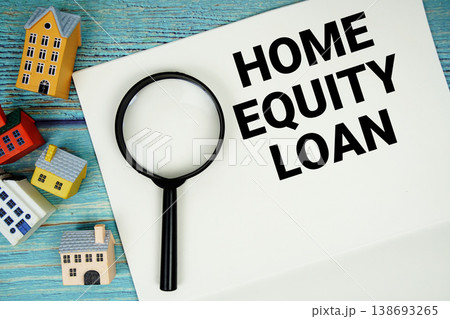Notepad with "Home Equity Loan" with magnifying glass and house model on wooden background 138693265