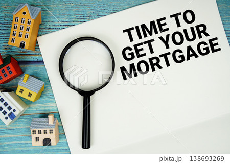 Notepad with "Time To Get Your Mortgage" with magnifying glass and house model on wooden background Notepad with "Time To Get Your Mortgage" with magnifying glass and house model on wooden background 138693269