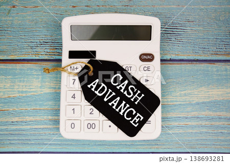Price tag with "CASH ADVANCE" on calculator on a rustic blue wooden surface Price tag with "CASH ADVANCE" on calculator on a rustic blue wooden surface 138693281