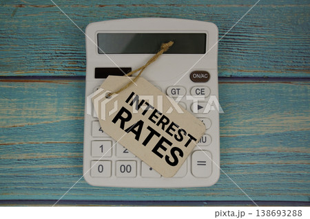 Price tag with "INTEREST RATES" on calculator on a rustic blue wooden surface 138693288