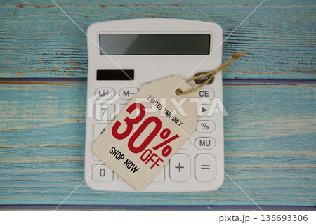 Sale 30% off Shop Now with price tag and calculator on wooden background 138693306