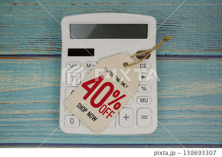 Sale 40% off Shop Now with price tag and calculator on wooden background 138693307